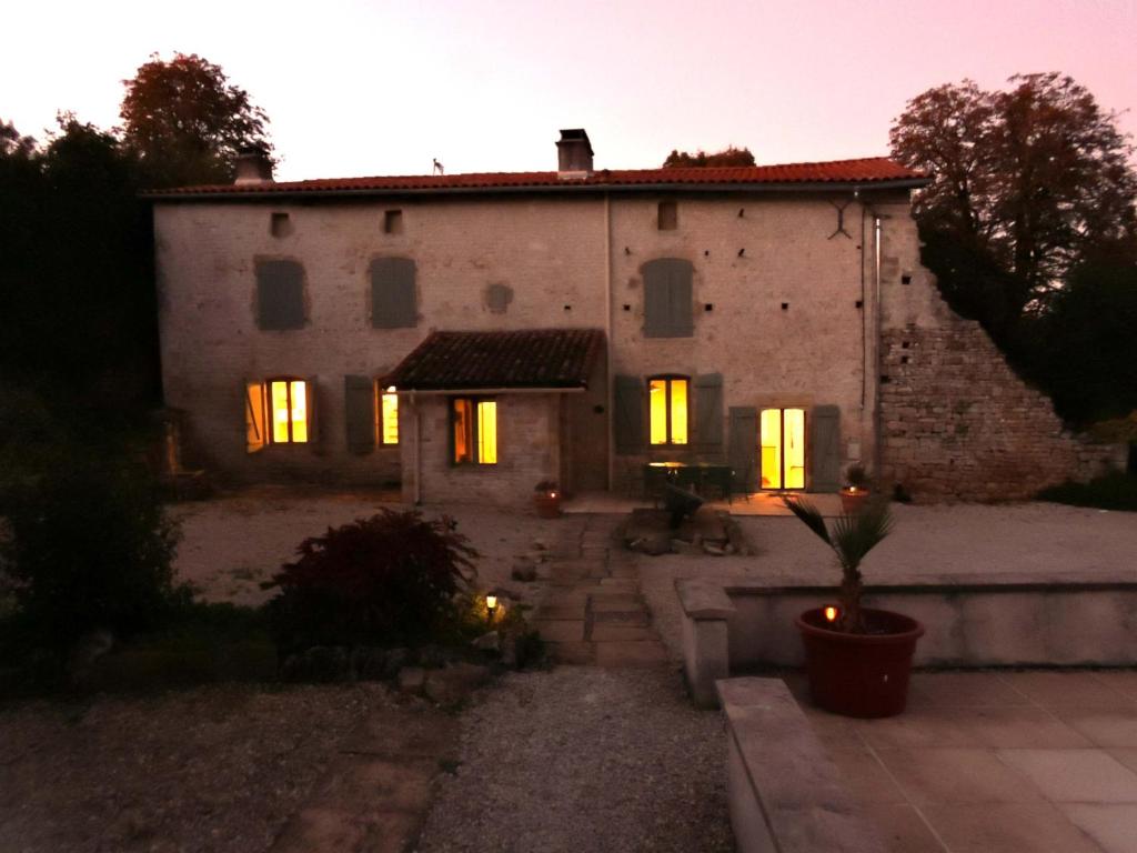 a large stone house with its lights on at Charente Cozy Family Winter Retreat in Theil-Rabier