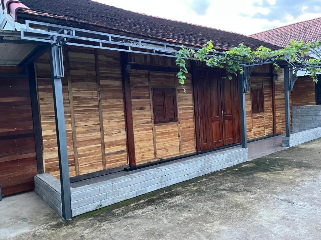 un edificio de madera con puertas de madera. en Home Dốc Mơ, en Xã Gia Tân