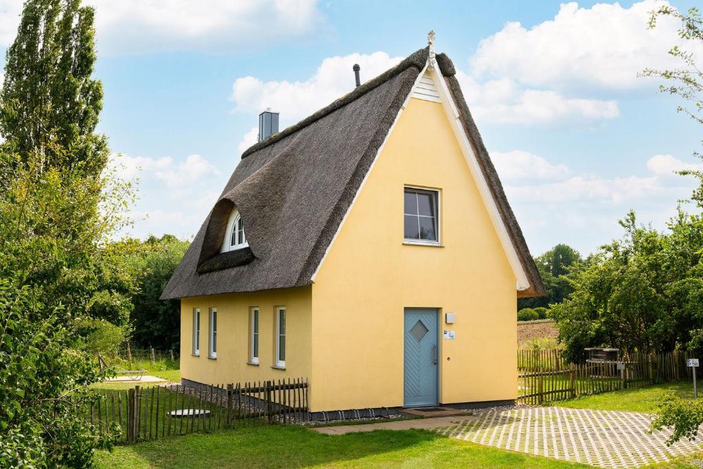 a yellow house with a thatched roof at Reethaus Schwan Mit Großem Grundstück in Gramkow