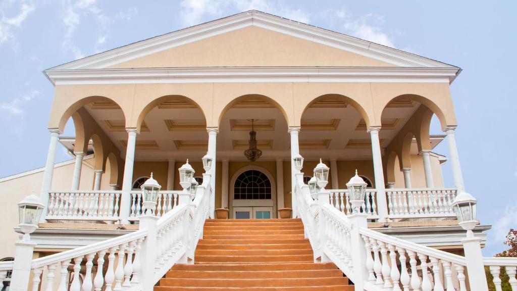 a large white house with a white staircase at Chateau Suites in Norristown