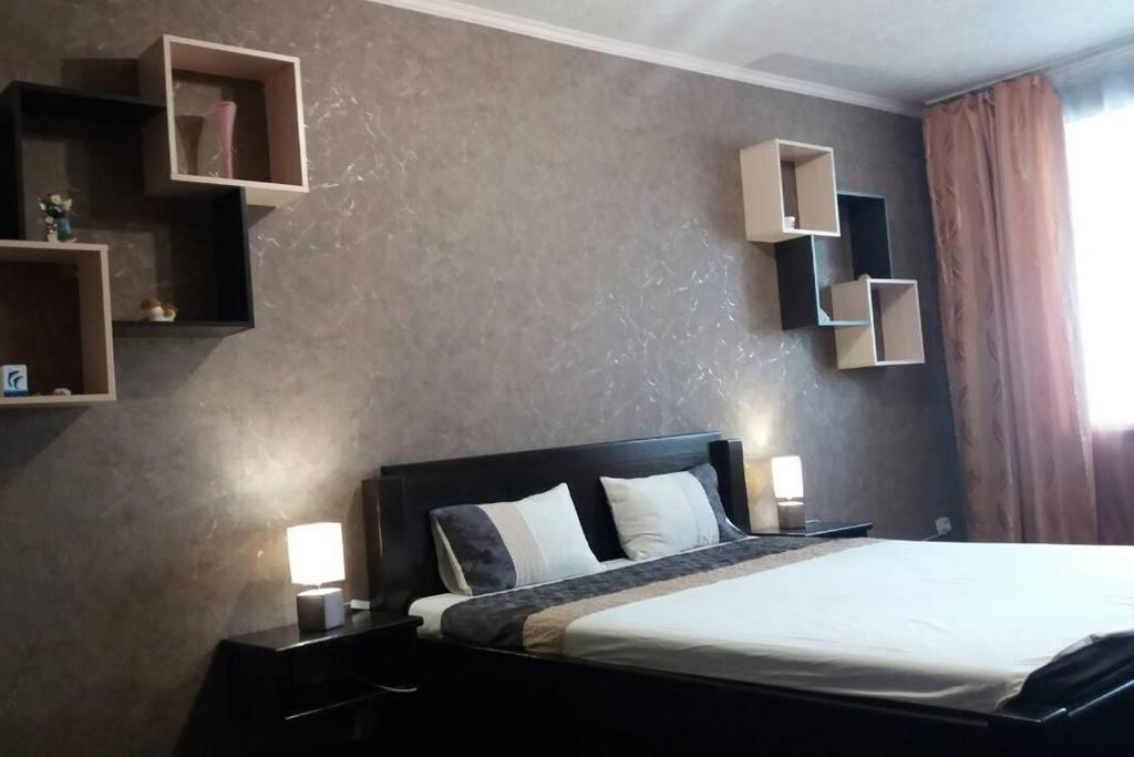 ein Schlafzimmer mit einem Bett mit zwei Leuchten in der Unterkunft Luxury apartment Slobozhansky Prospekt in Nizhnedneprovsk