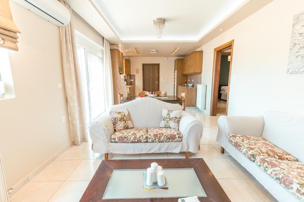 un salon avec deux canapés et une table dans l'établissement The Saltwater Suite 1 minute Beach, à Kos