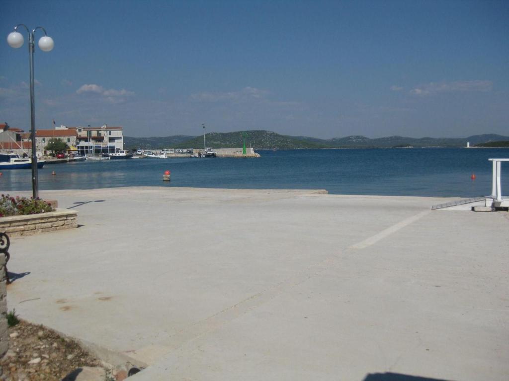 a large parking lot next to a large body of water at Apartment Mit Terrasse Direkt Am Meer in Betina