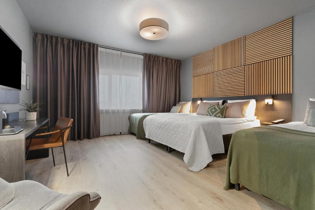 Hotel room with two beds and a desk at Konvin Hotel