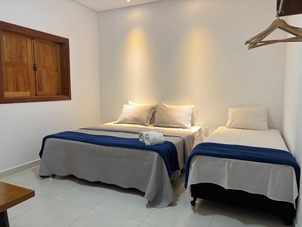 une chambre avec deux lits dans une pièce dans l'établissement Pousada Império de Minas, à Capitólio