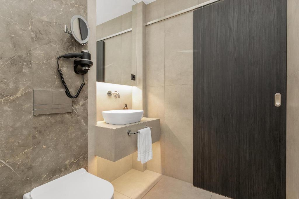 Bathroom with sink and toilet at Konvin Hotel