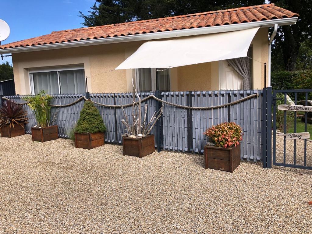 a blue fence with potted plants in front of a house at maisonnette entre forêt et occéan in Vendays-Montalivet