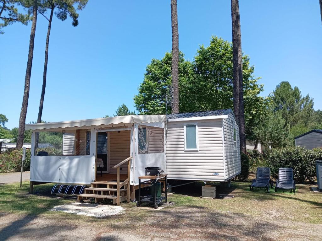 ein winziges Haus, das vor Palmen geparkt ist in der Unterkunft MH 229 2 chambres et 1 salle de bain dans camping 4 étoiles avec parc aquatique in Saint-Julien-en-Born