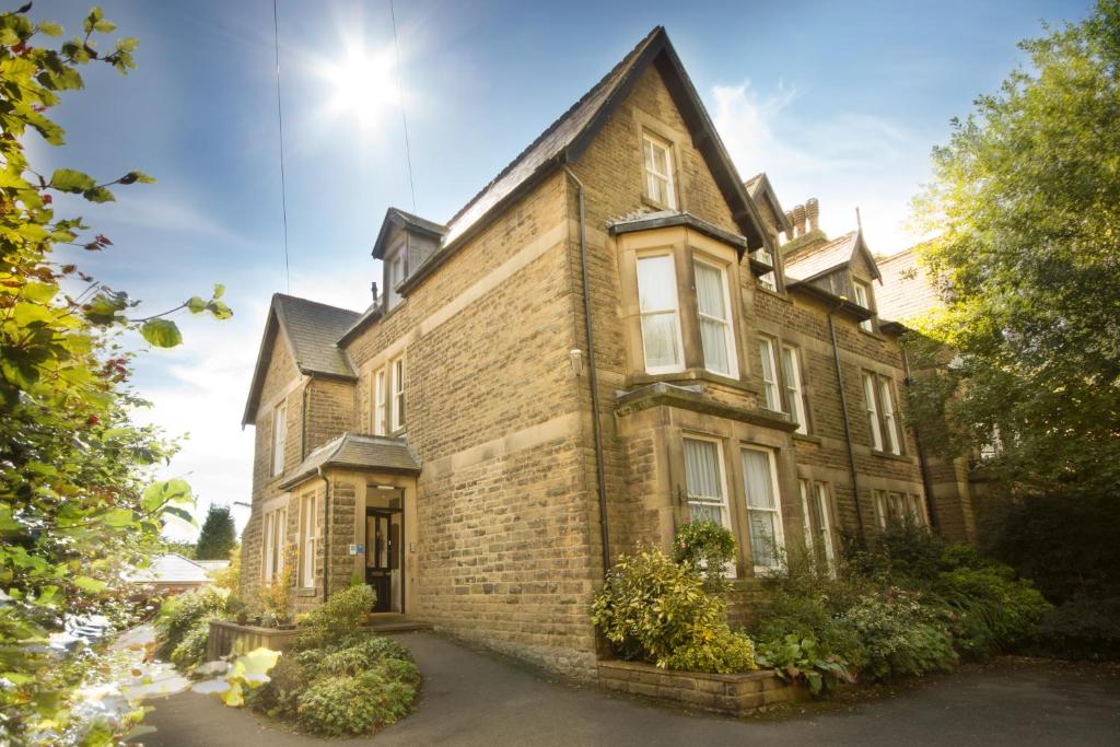 ein altes Backsteingebäude mit der Sonne am Himmel in der Unterkunft 9 Green Lane Bed and Breakfast in Buxton