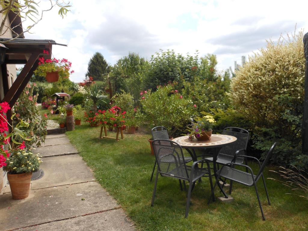 une table et des chaises dans un jardin fleuri dans l'établissement Hohlfeld, à Bad Schandau