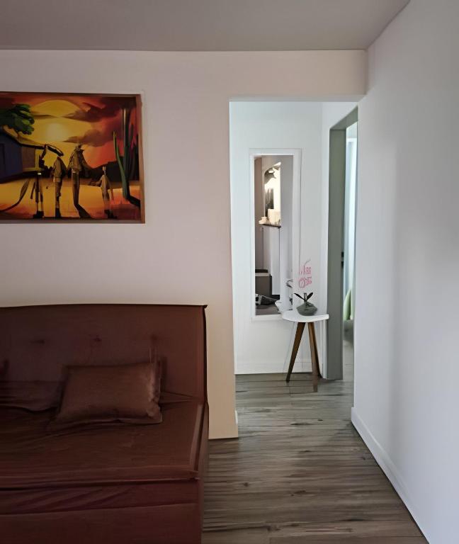 Una sala de estar con un sofá y un cuadro en la pared. en Mar Perto, Estilo e Conforto, en Ilha da Restinga