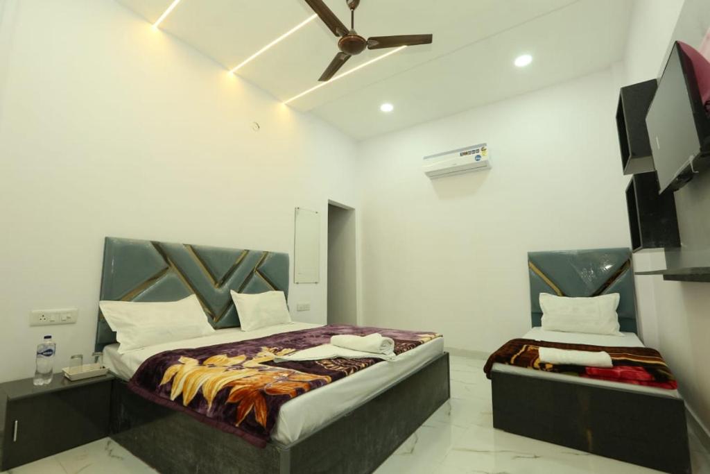 Un dormitorio con dos camas y un ventilador de techo. en Aditya Home Stay, en Amritsar