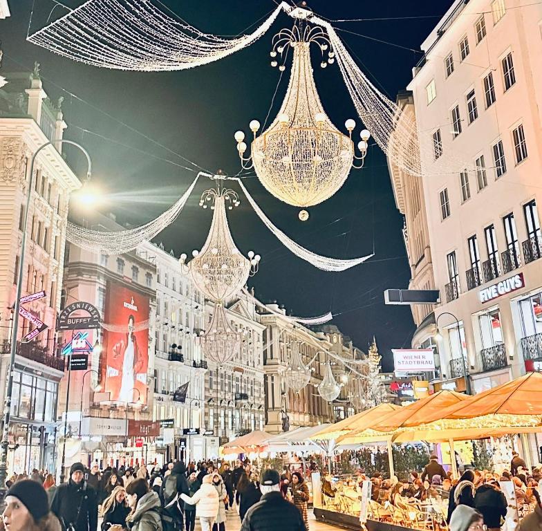 Una multitud de personas caminando por una calle iluminada en Patrikapartman2, en Viena