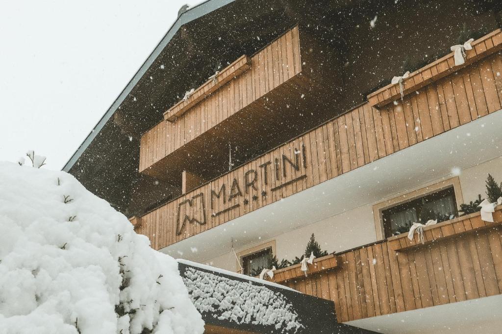 Un edificio con un cartel en la nieve. en Hotel Martini Kaprun inkluding breakfast & free parking, en Kaprun