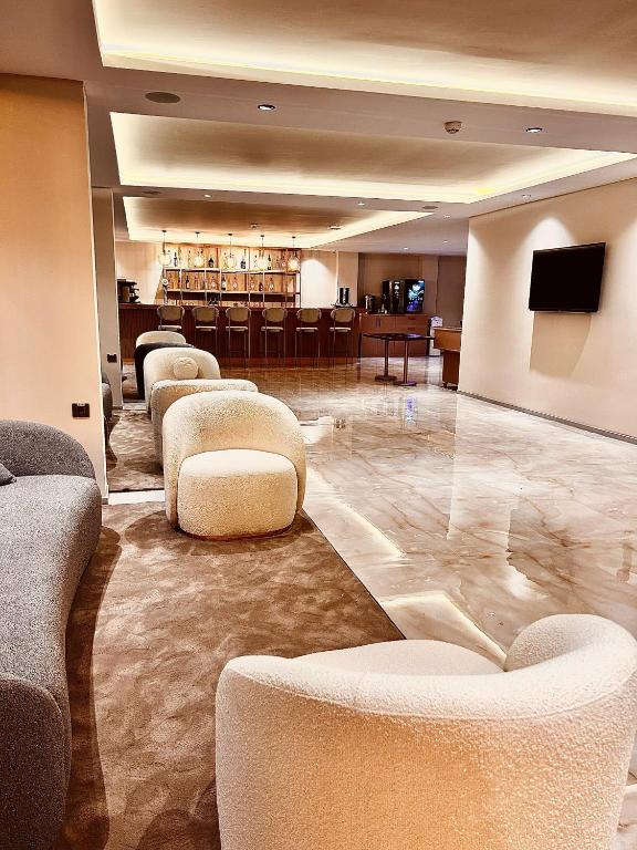 un vestíbulo con sofás, sillas y TV en FIFTY5 Suite Hotel, en Marmaris