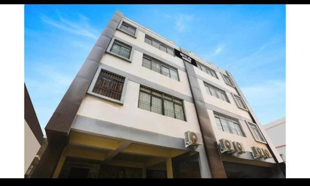 un edificio blanco alto con ventanas en la parte superior en Magadh Kutumb Guest House, en Patna