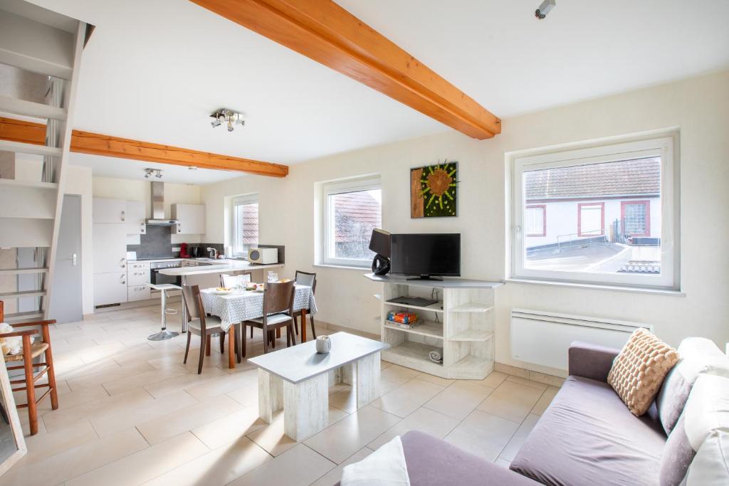 un salon avec un canapé et une table dans l'établissement Appartement agréable proche Colmar, à Andolsheim