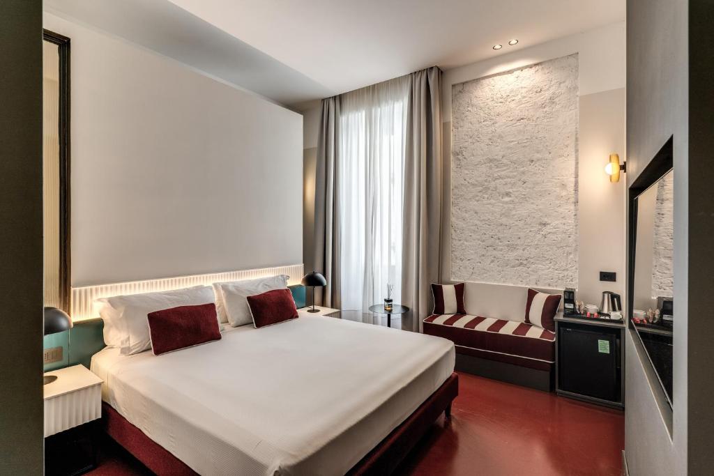 a hotel room with a large bed and a chair at Adaram Suites in Naples
