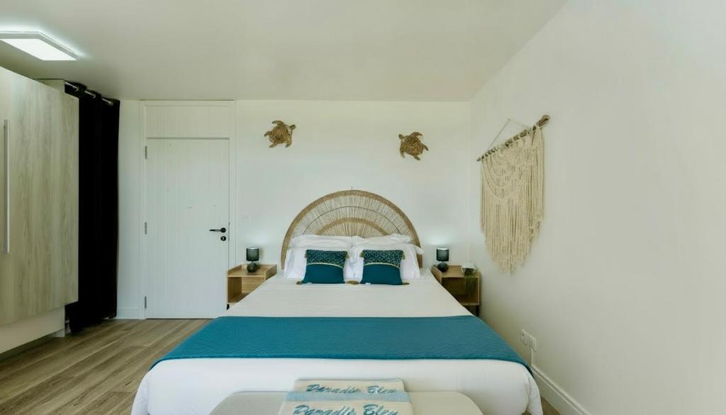 Un dormitorio con una cama grande con almohadas azules. en Le PARADIS BLEU VUE MER, en Saint-François