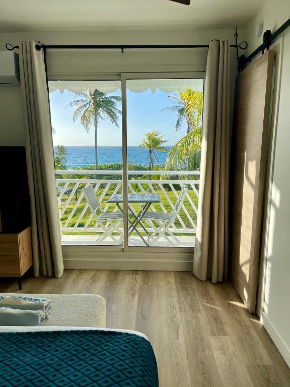 a bedroom with a window with a view of the ocean at Le PARADIS BLEU VUE MER in Saint-François