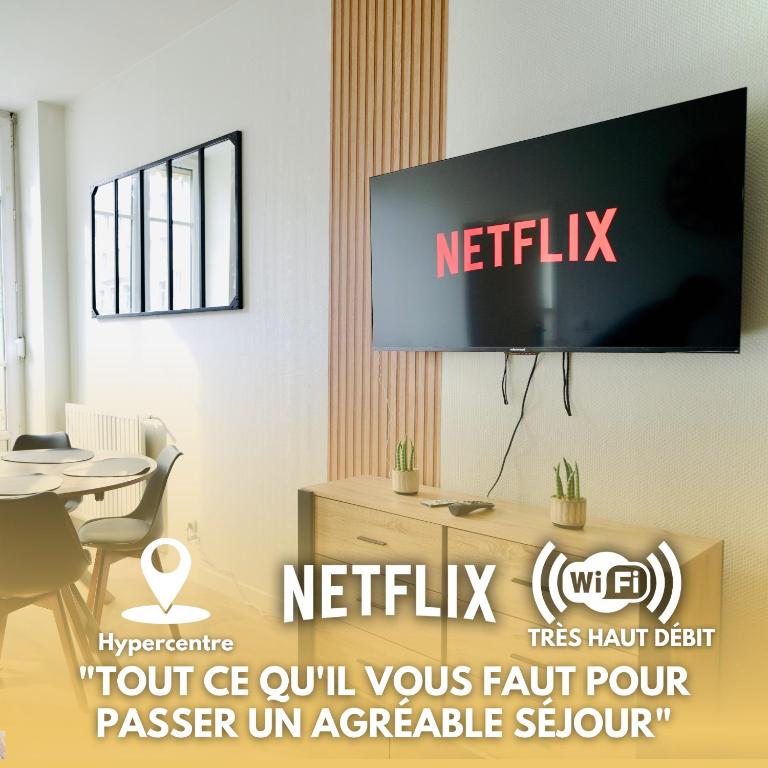 a television on a wall in a room with a table at Modern & Hypercentre, Private Balcony in Saint-Étienne