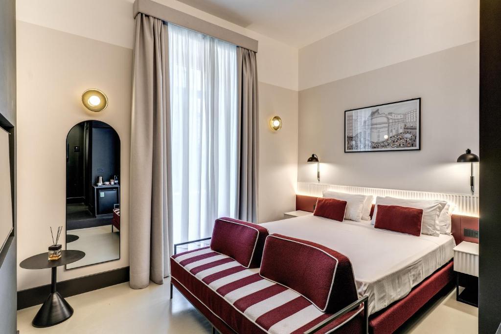 ein Hotelzimmer mit einem Bett und zwei Stühlen in der Unterkunft Adaram Suites in Neapel