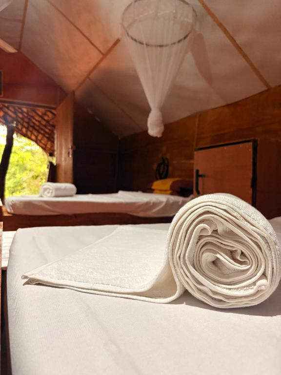 a rolled up towel on a bed in a tent at Elephant point tree house in Sigiriya