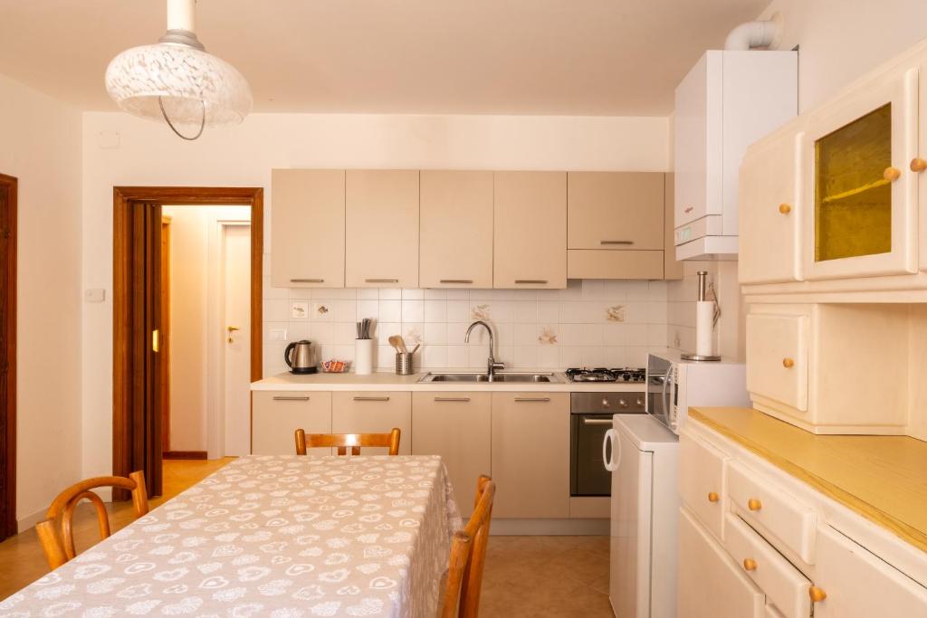 a kitchen with white cabinets and a table with a dining room at Garden Dream in Valle di Cadore