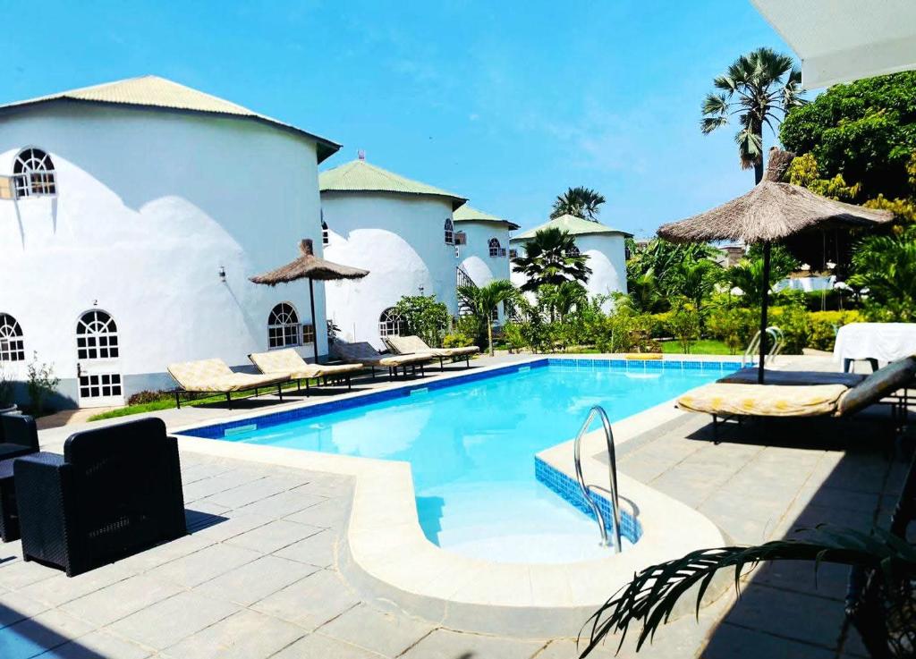 a swimming pool in front of a house at Afro Garden in Sere Kunda