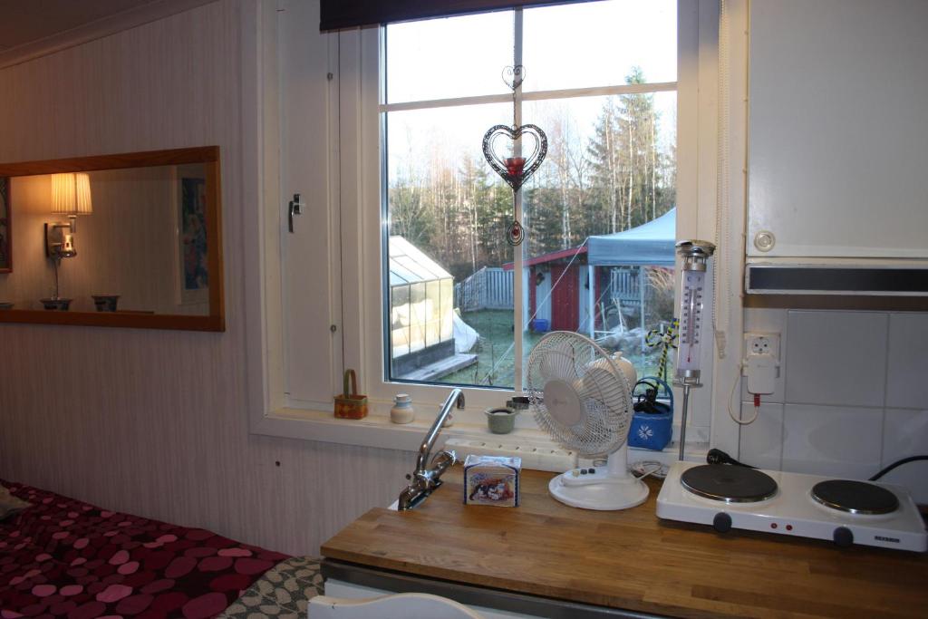 um balcão de cozinha com uma ventoinha e uma janela em Storsandskär em Umeå