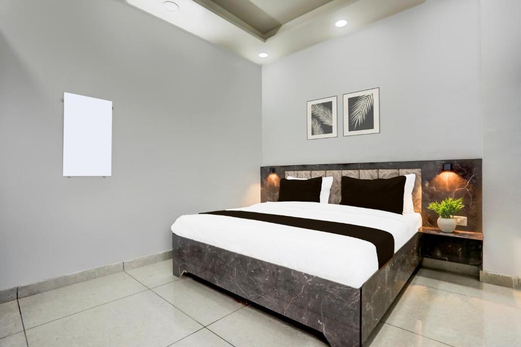 a bedroom with a large bed in a room at Hotel O Shivoham in Indirapuram