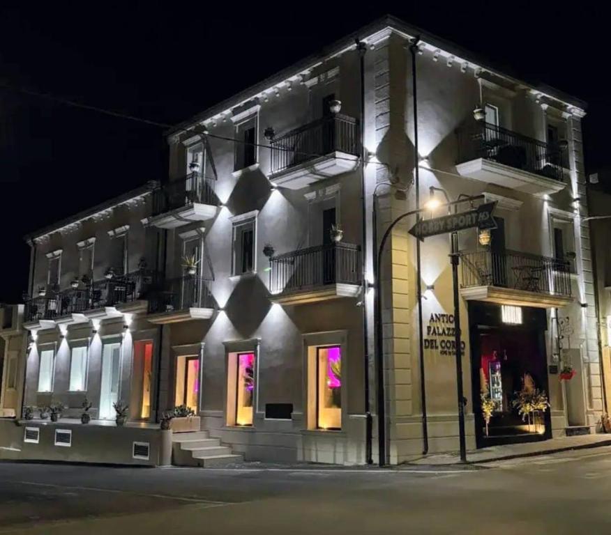 a building with lights on the side of it at night at Antico Palazzo del Corso by Home Dardano in Mirto Crosia