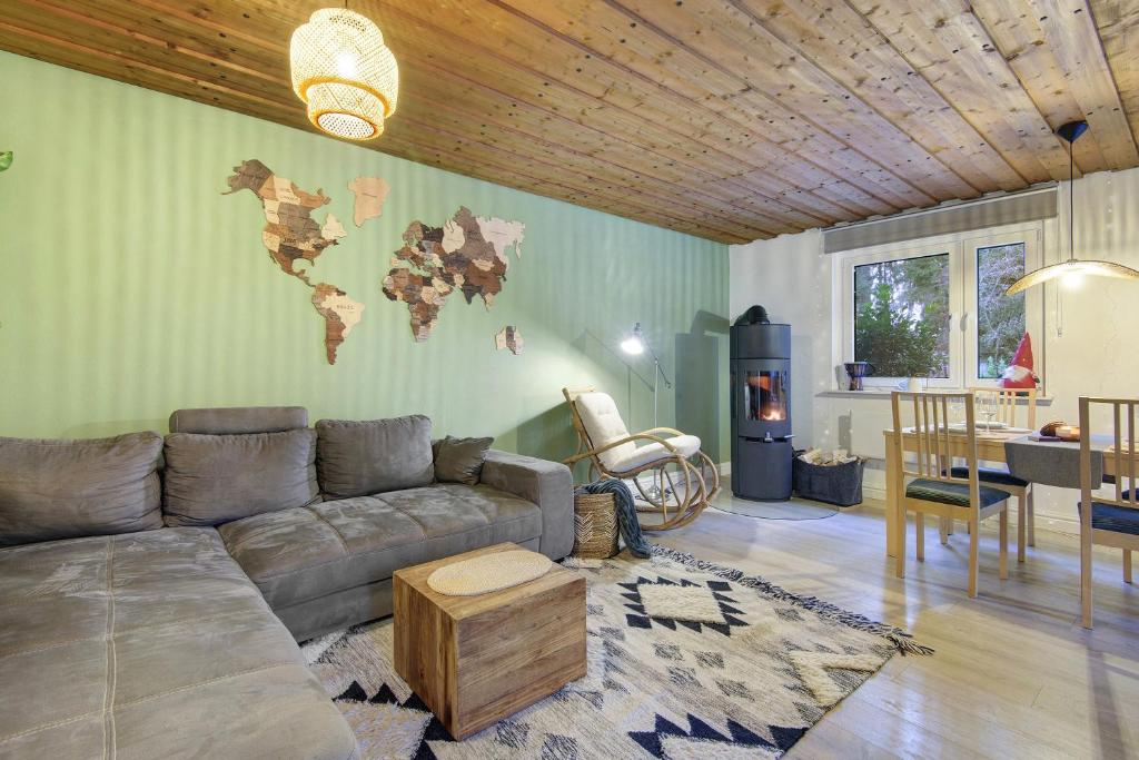 een woonkamer met een bank en een wereldkaart aan de muur bij Ferienhaus am Neubäuer See in Neubäu