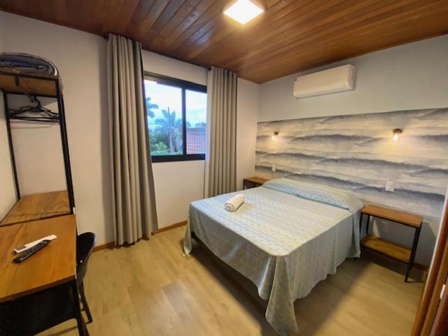 a bedroom with a bed and a table and a desk at Venere - Bed and Breakfast in Florianópolis