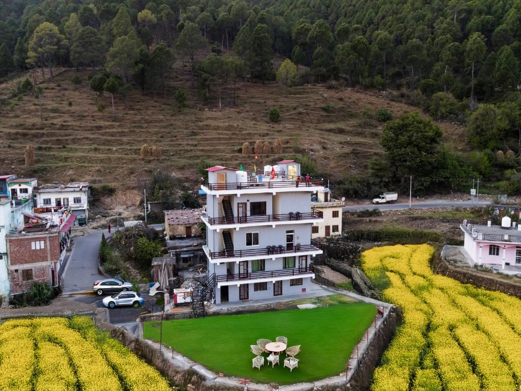une vue aérienne d'une grande maison avec une cour verte dans l'établissement Sukoon Inn Hotel & Restaurant, à Someshwar