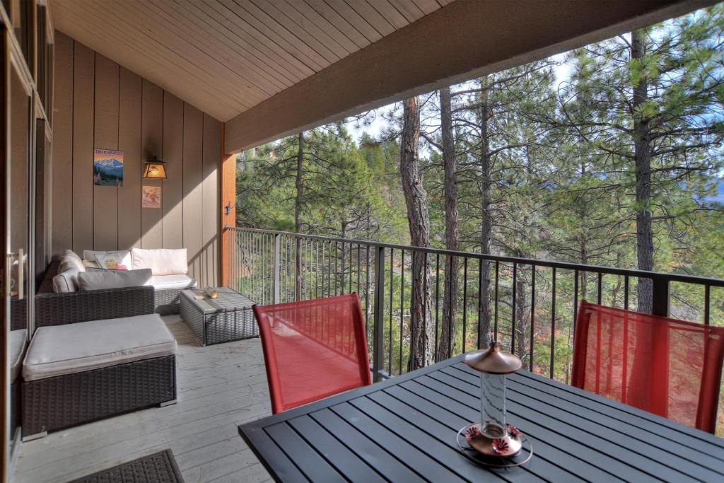 eine abgeschirmte Veranda mit einem Tisch und Stühlen in der Unterkunft Tamarron PineCone 854 in Durango