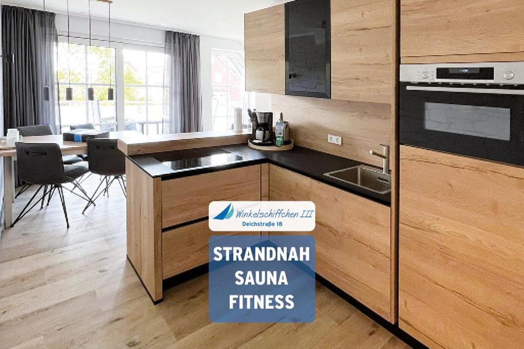 a kitchen with a sink and a stove top oven at Winkelschiffchen III mit Sauna in Juist