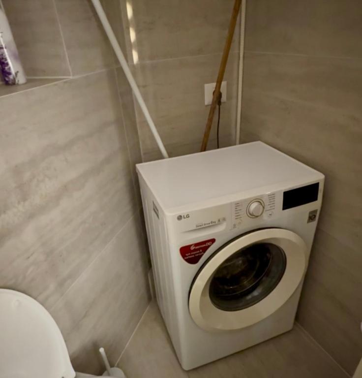 a washing machine in a bathroom next to a toilet at Sara exclusive in Mevasseret Zion
