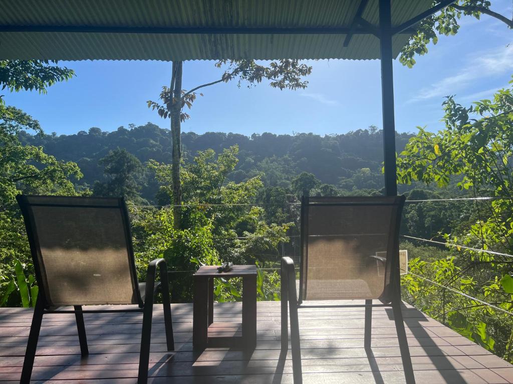 two chairs and a table on a deck with a view at Casita Anya in Hone Creek