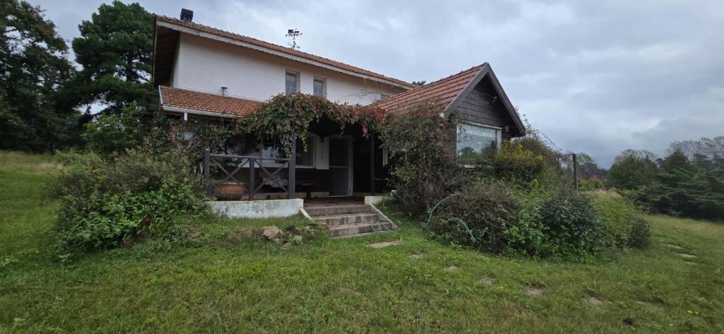 ein kleines Haus auf einem Hügel mit einem Hof in der Unterkunft Los Alerces, Villa Berna in La Porteña