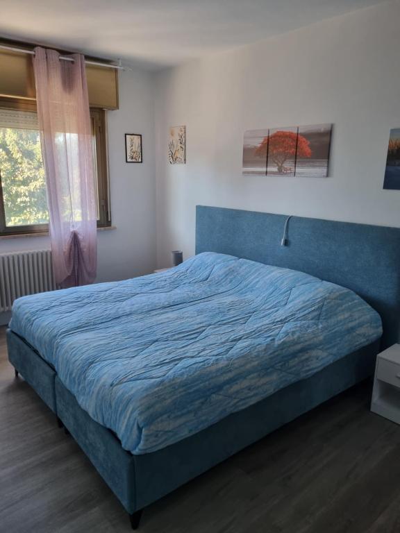 1 dormitorio con cama azul y manta azul en Affittacamere Ely, en San Giorgio di Nogaro