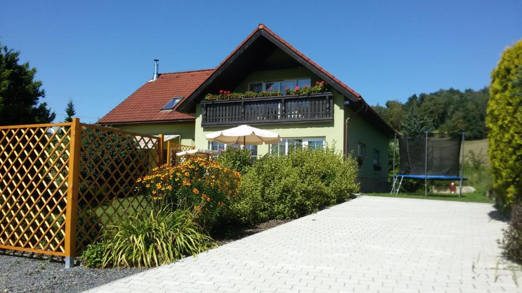 a house with a balcony with an umbrella at Apartment Amélie in Rožnov pod Radhoštěm