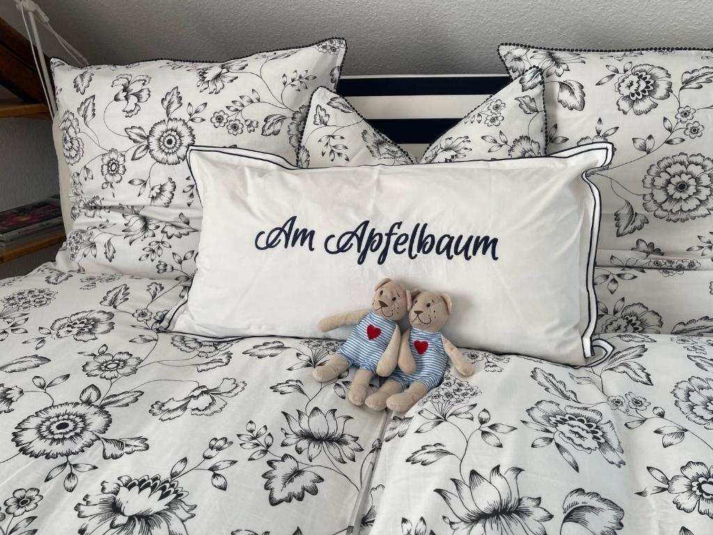 Dos osos de peluche sentados en una cama con una almohada en Am Apfelbaum, ein Ferienhaus zwischen Rhein und Mosel, en Kastellaun