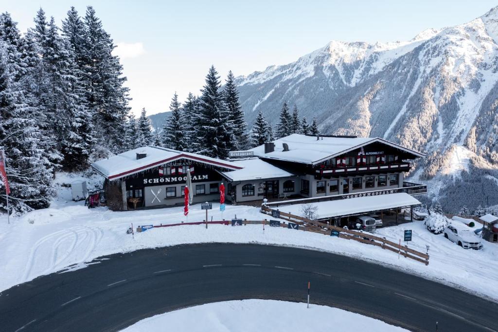 Un refugio de esquí en la nieve con un puente en Schönmoosalm, en Krimml