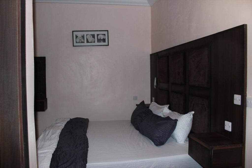 a bedroom with a bed with black pillows on it at Folks Apartment in Mama