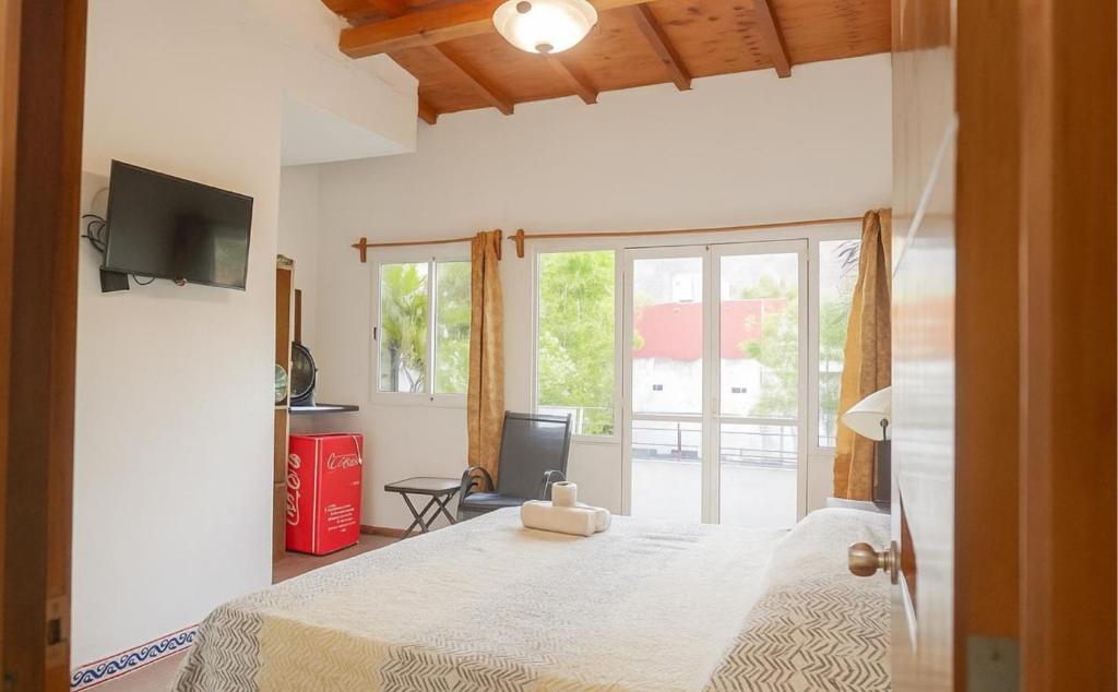 Un dormitorio con una cama grande y un televisor. en Hotel Casa Maximiliano, en Tepoztlán
