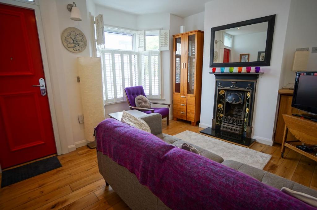 a living room with a couch and a fireplace at Charming 2 BDR Home with Garden and Light in London