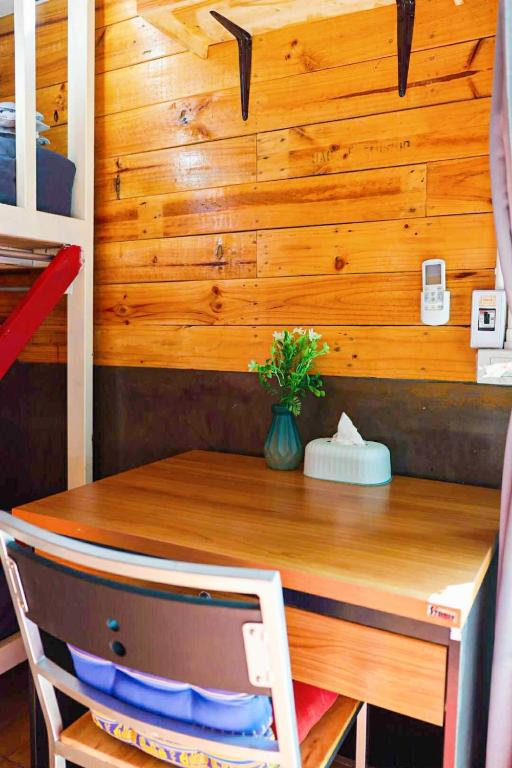 a table in a room with a wooden wall at Stop by stay Pai in Pai