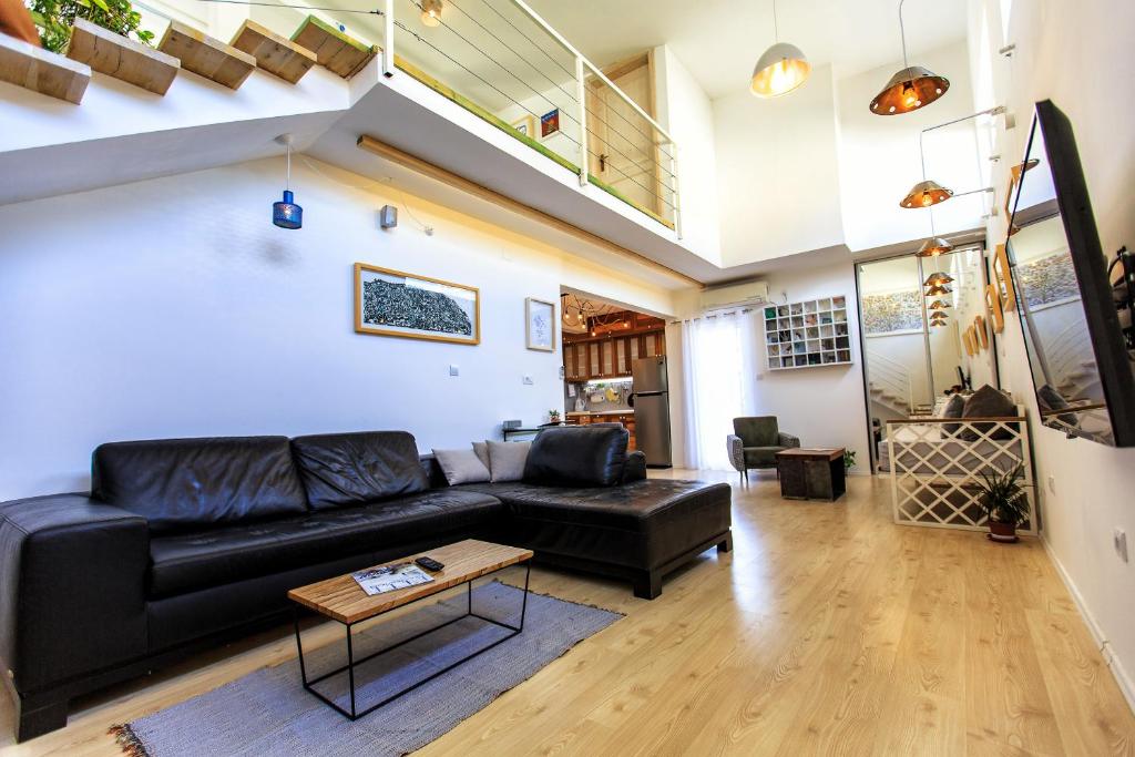 a living room with a black leather couch and a table at Apartments Rux de Luxe in Bar