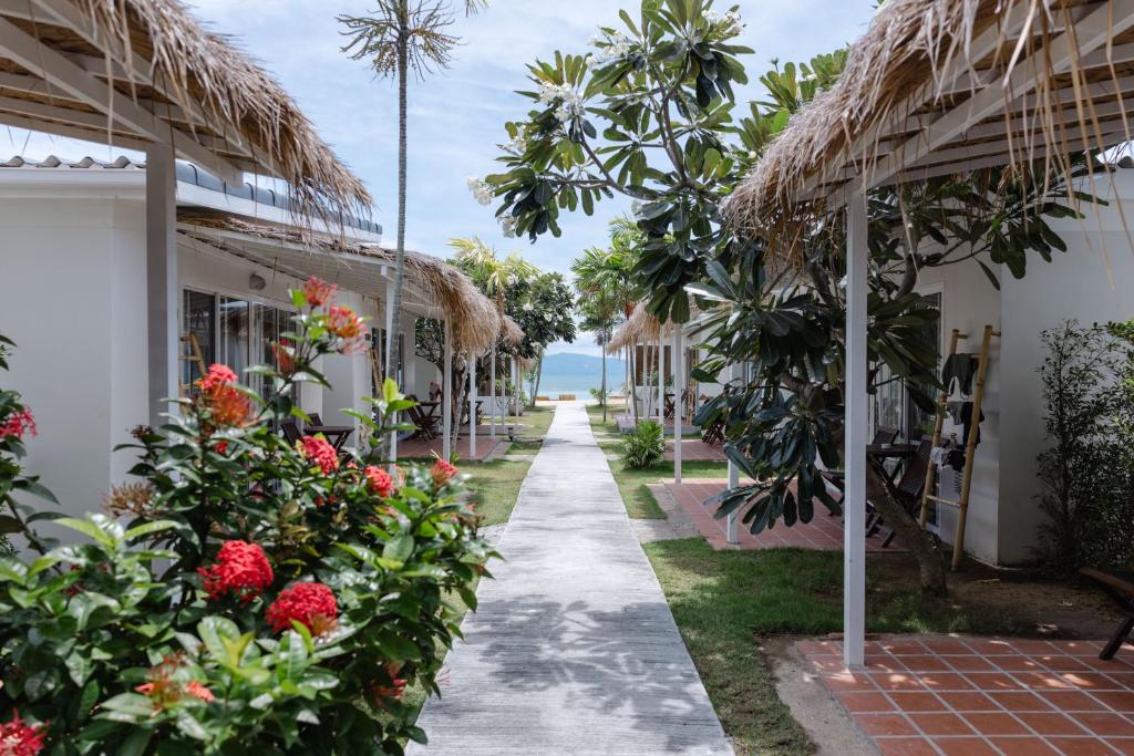 a walkway through the resort with flowers and plants at Sea Escapes Resort in Thongsala